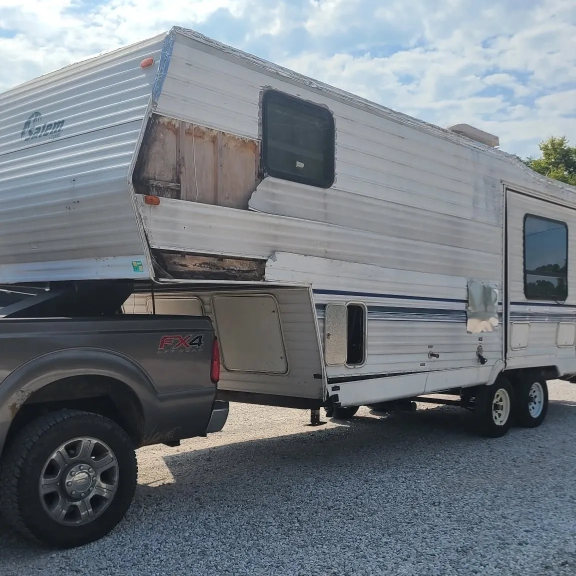 Chums Junk Removal hauling away an old, damaged fifth-wheel camper